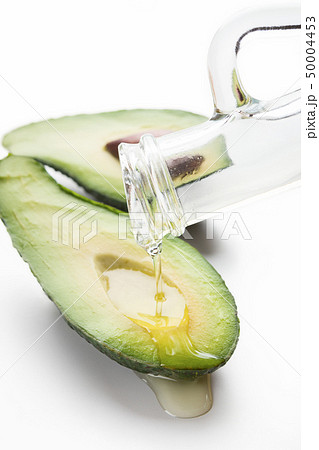 Avocado with oil on white 50004453
