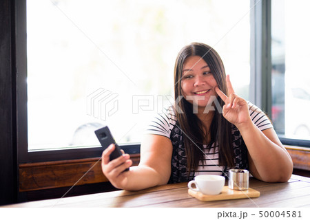 Beautiful overweight Asian woman relaxing at the coffee shop 50004581