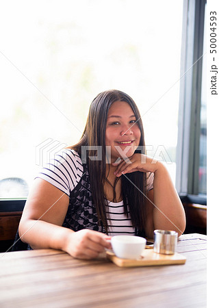 Beautiful overweight Asian woman relaxing at the coffee shop Beautiful overweight Asian woman relaxing at the coffee shop 50004593