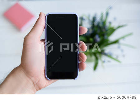 Male hand with a smartphone. Black blank screen. 50004788