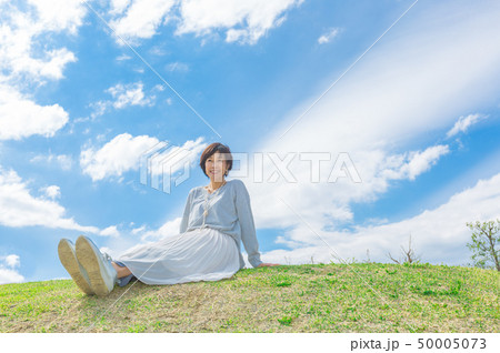 青空の下 芝生の丘の上で  さわやかなアラフォー女性  50005073