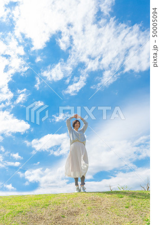 青空の下 芝生の丘の上で さわやかなアラフォー女性 青空の下 芝生の丘の上で さわやかなアラフォー女性 50005094