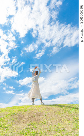 青空の下 芝生の丘の上で さわやかなアラフォー女性 青空の下 芝生の丘の上で さわやかなアラフォー女性 50005096