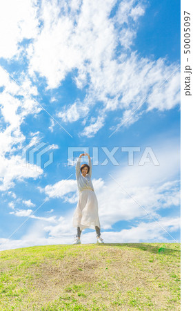 青空の下 芝生の丘の上で  さわやかなアラフォー女性  50005097