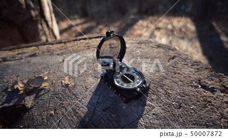 The theme is tourism and technology. Close-up navigation compass black magnetic needle lying on a 50007872