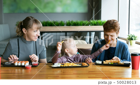 Women of the same family having lunch in a cafe. Women of the same family having lunch in a cafe. 50028013