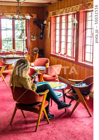 Young woman is sitting in a cafe with a smartphone 50032556
