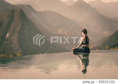 woman practice yoga Lotus pose on the pool 50035191