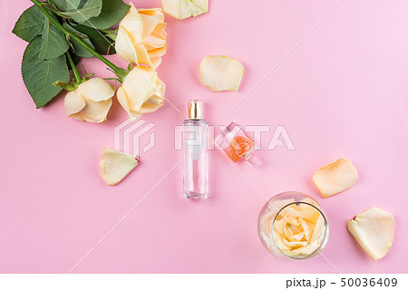 Perfume bottles with flowers on pink background. Perfumery, cosmetics, fragrance collection. Flat Perfume bottles with flowers on pink background. Perfumery, cosmetics, fragrance collection. Flat 50036409