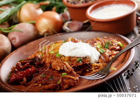 Homemade tasty potato pancakes in clay dish with Homemade tasty potato pancakes in clay dish with 50037071
