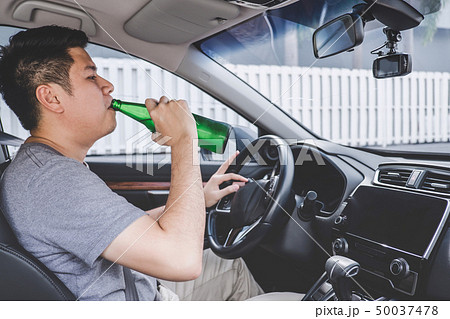 Young asian man drives a car with drunk a bottle 50037478