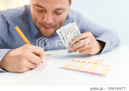 Photo of male filling out lottery ticket and euro. 50038477