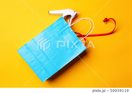 Top view of blue shopping bag with stylish shoes and red belt Top view of blue shopping bag with stylish shoes and red belt 50039119