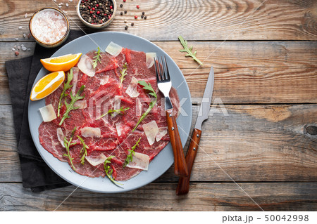 Marbled beef carpaccio with arugula. 50042998