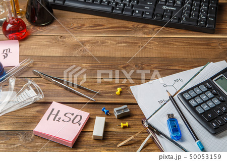 Chemical flasks, tweezers, keyboard, notebooks on a wooden table with copyspase. Chemical flasks, tweezers, keyboard, notebooks on a wooden table with copyspase. 50053159