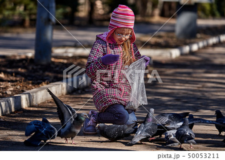 A girl child in a red jacket, hat and glasses A girl child in a red jacket, hat and glasses 50053211