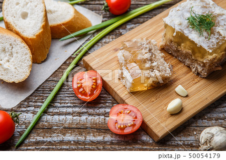 Homemade jelly meat with mustard, bread, tomatoes and garlic on the table. Holodets Homemade jelly meat with mustard, bread, tomatoes and garlic on the table. Holodets 50054179