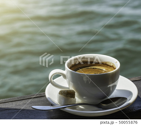A small white porcelain espresso cup on a saucer 50055876
