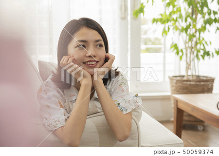 ソファー　リラックス　ほおづえ　ライフスタイル　若い女性 50059374