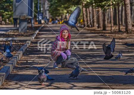 Girl in a red jacket, hat and glasses chasing 50063120