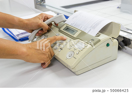 hand man are using a fax machine in the office  50066425