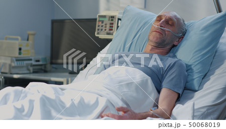 Man lying in hospital bed 50068019