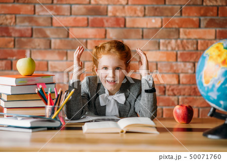 Tired schoolgirl doing homework at the table Tired schoolgirl doing homework at the table 50071760