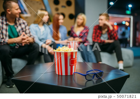 Group of teenagers relax on couch in cinema hall Group of teenagers relax on couch in cinema hall 50071821