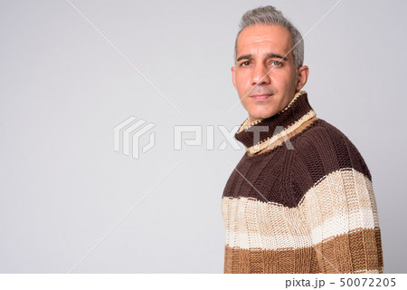 Profile view of handsome Persian man looking at camera ready for winter 50072205