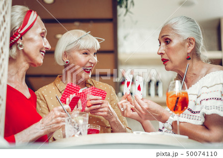 Nice pleasant woman showing her cards to friends Nice pleasant woman showing her cards to friends 50074110