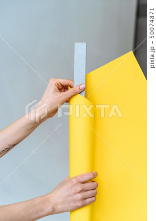 Women's hands wrap a gray nail file in paper 50074871