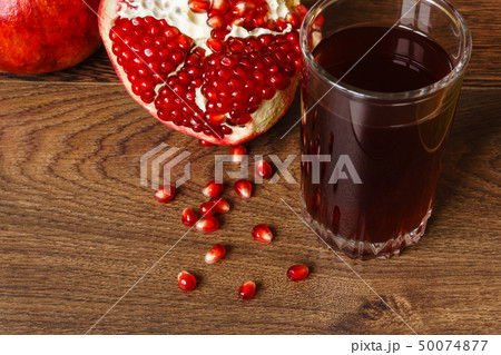 red pomegranate fruits, seeds and glass with juice 50074877