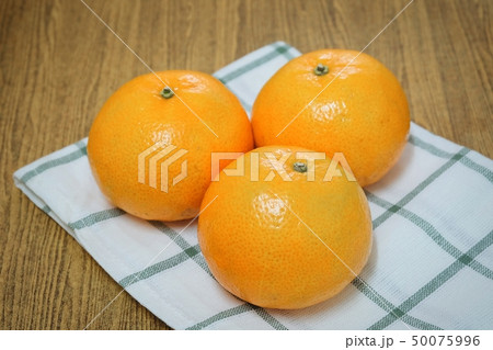 Three Ripe Oranges on A Wooden Table 50075996