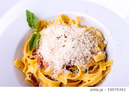 Classic Carbonara pasta, spaghetti with pancetta, bacon, egg, parmesan cheese and green arugula 50076362