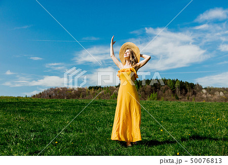 Beautiful girl in yellow dress and on mountain meadow with dandelions. Beautiful girl in yellow dress and on mountain meadow with dandelions. 50076813