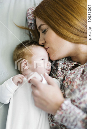 Woman kissing her newborn son's head Woman kissing her newborn son's head 50081002