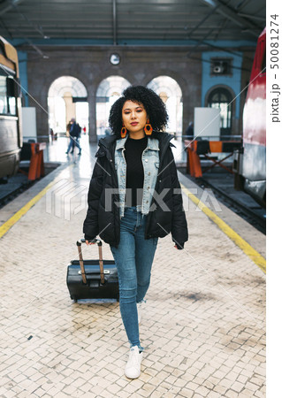 Young woman pulling suitcase in railway station 50081274