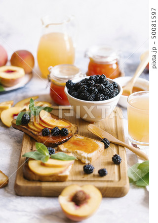 Breakfast spread with blackberries, peaches, toast and apricot jam 50081597