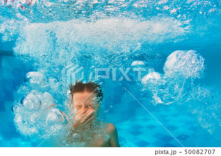 Boy diving in swimming pool 50082707