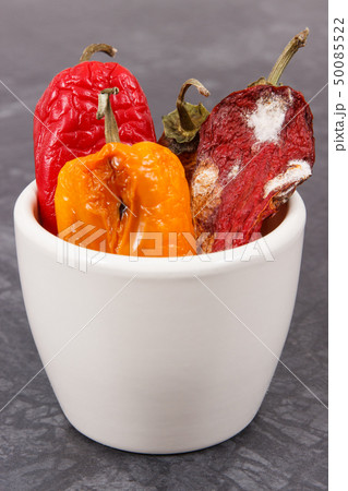 Moldy and wrinkled peppers in white bowl Moldy and wrinkled peppers in white bowl 50085522