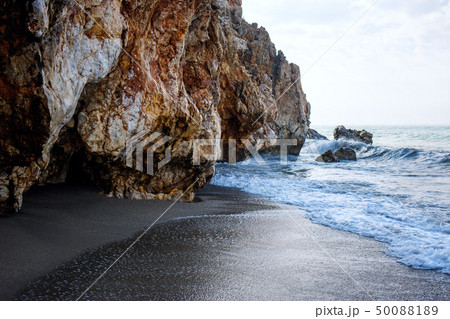 Sandy beach and soft blue ocean wave with white foam. 50088189