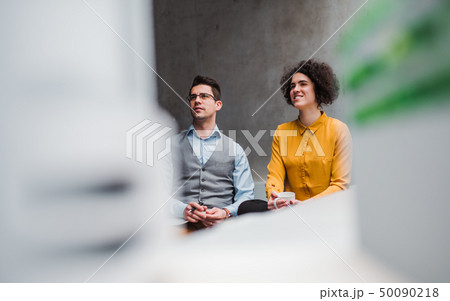 Two young businesspeople sitting in office. Copy space. 50090218