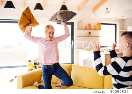 A young woman with two children having fun at home. 50090332