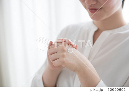 ハンドクリームを塗る若い日本人女性の手元 50090602