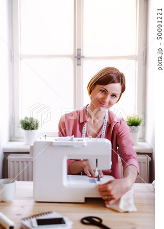 Young creative woman in a studio, working. A startup of tailoring business. Young creative woman in a studio, working. A startup of tailoring business. 50091221