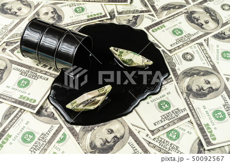 Spilled oil from a barrel to a dollar bill background.Oil barrel price concept Spilled oil from a barrel to a dollar bill background.Oil barrel price concept 50092567