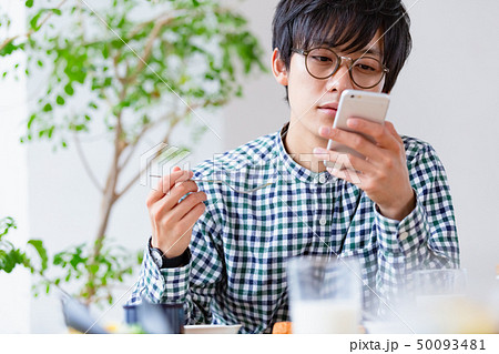 朝食シーン　スマホを見る男性 50093481