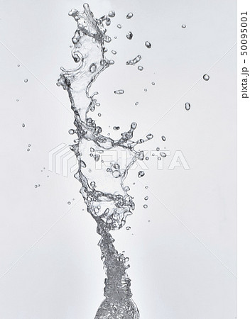 ペットボトルから勢いよく飛び出す水しぶきの写真素材