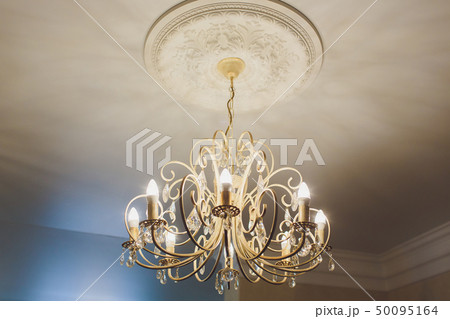 luxury expensive chandelier hanging under ceiling in palace. luxury expensive chandelier hanging under ceiling in palace. 50095164