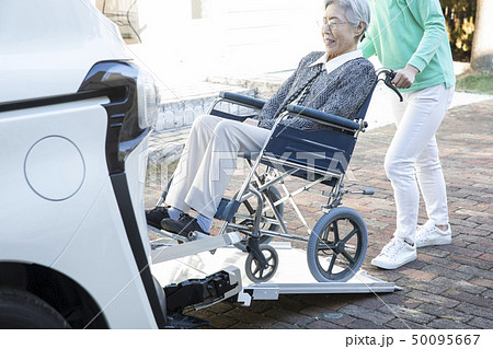 福祉車両に車椅子の高齢者を乗せるヘルパー 50095667